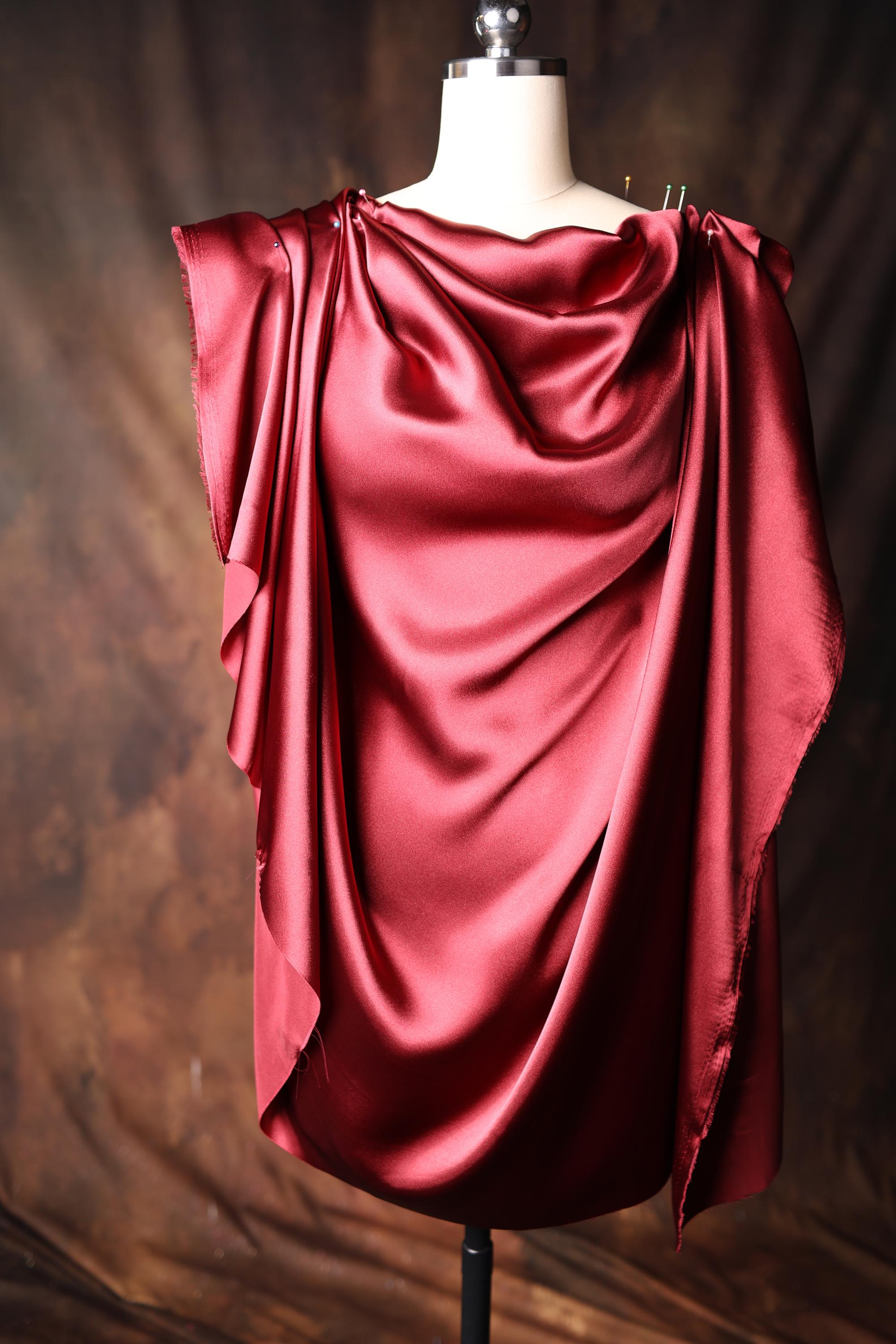 a dress on a mannequin with a red draped over it