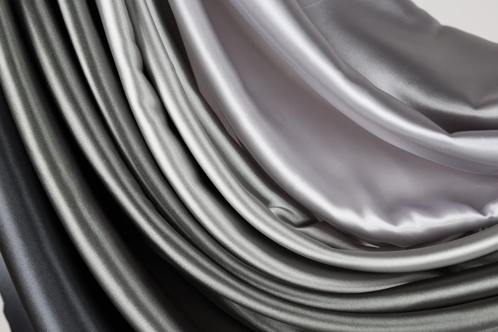 a close-up view of a collection of grey and black fabric swatches, creating a visually striking contrast.