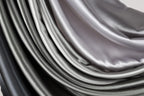 a close-up view of a collection of grey and black fabric swatches, creating a visually striking contrast.
