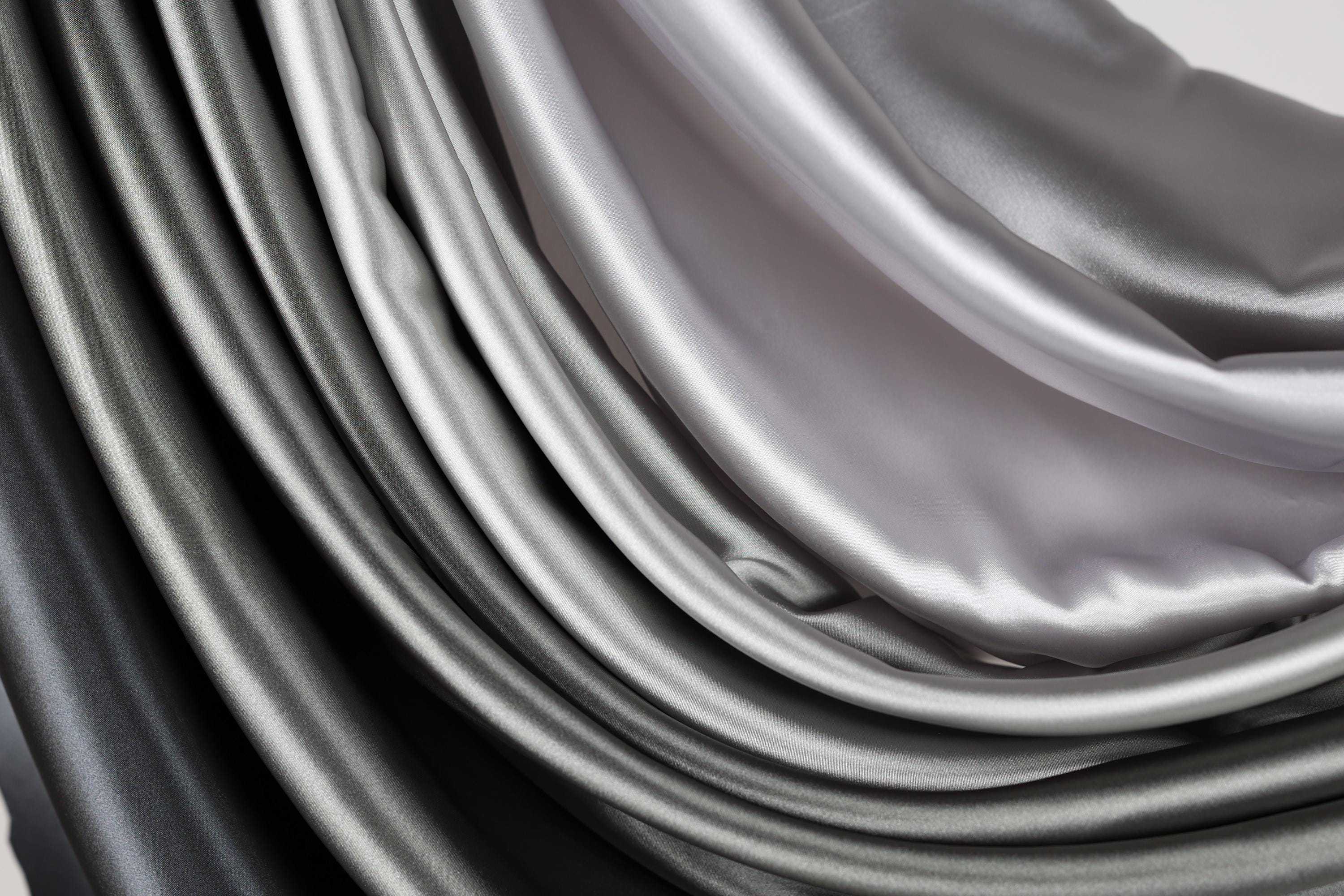 a close-up view of a collection of grey and black fabric swatches, creating a visually striking contrast.