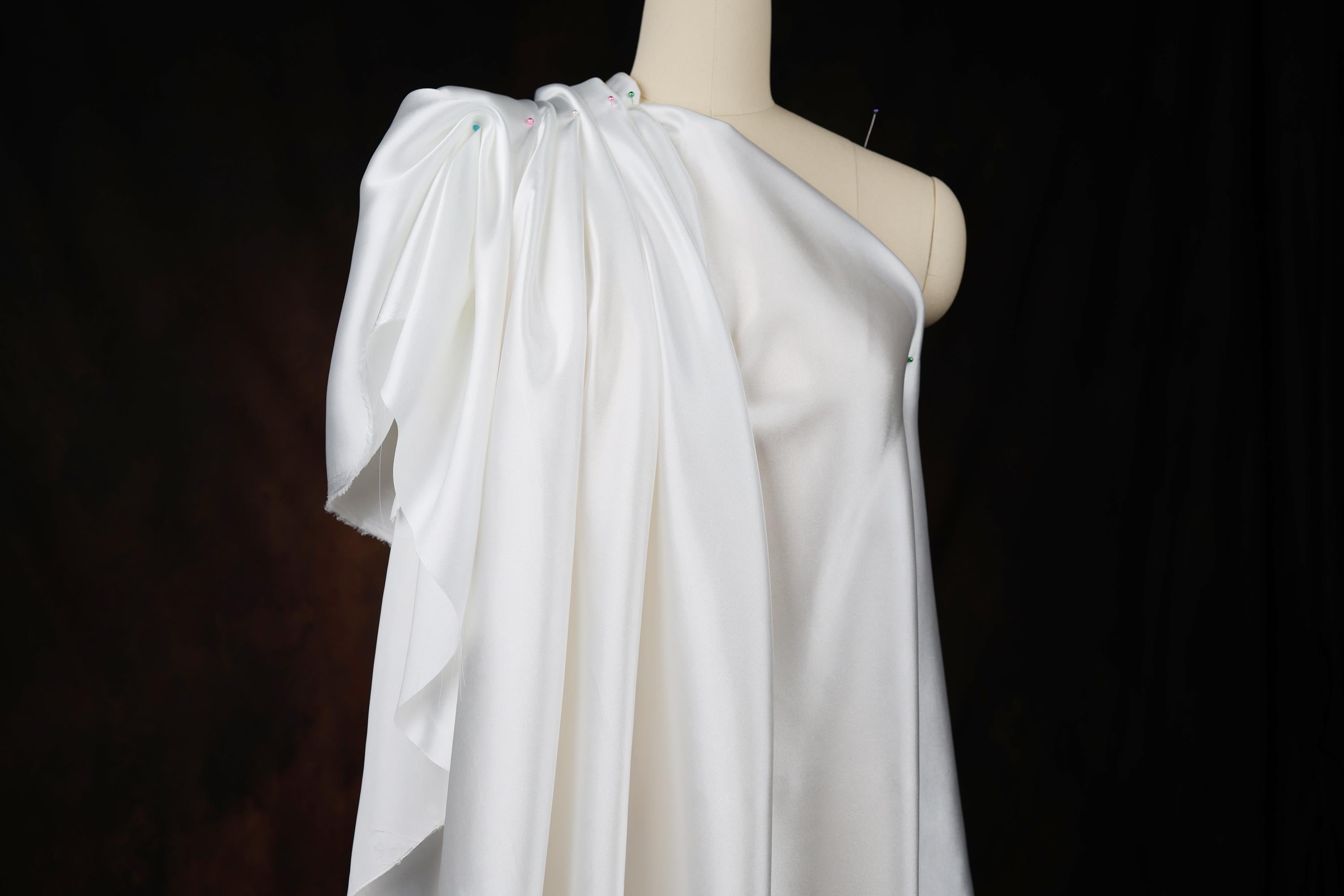 a white dress on a mannequin on a black background