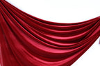 a red velvet curtain or fabric hanging in a curved, flowing manner.