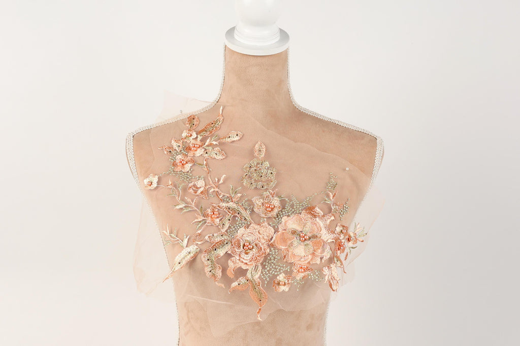 A mannequin with a floral design on its bust, featuring a combination of pink and peach flowers.