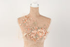 A mannequin with a floral design on its bust, featuring a combination of pink and peach flowers.