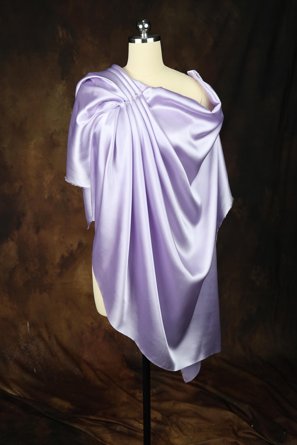 a mannequin wearing a purple draped dress