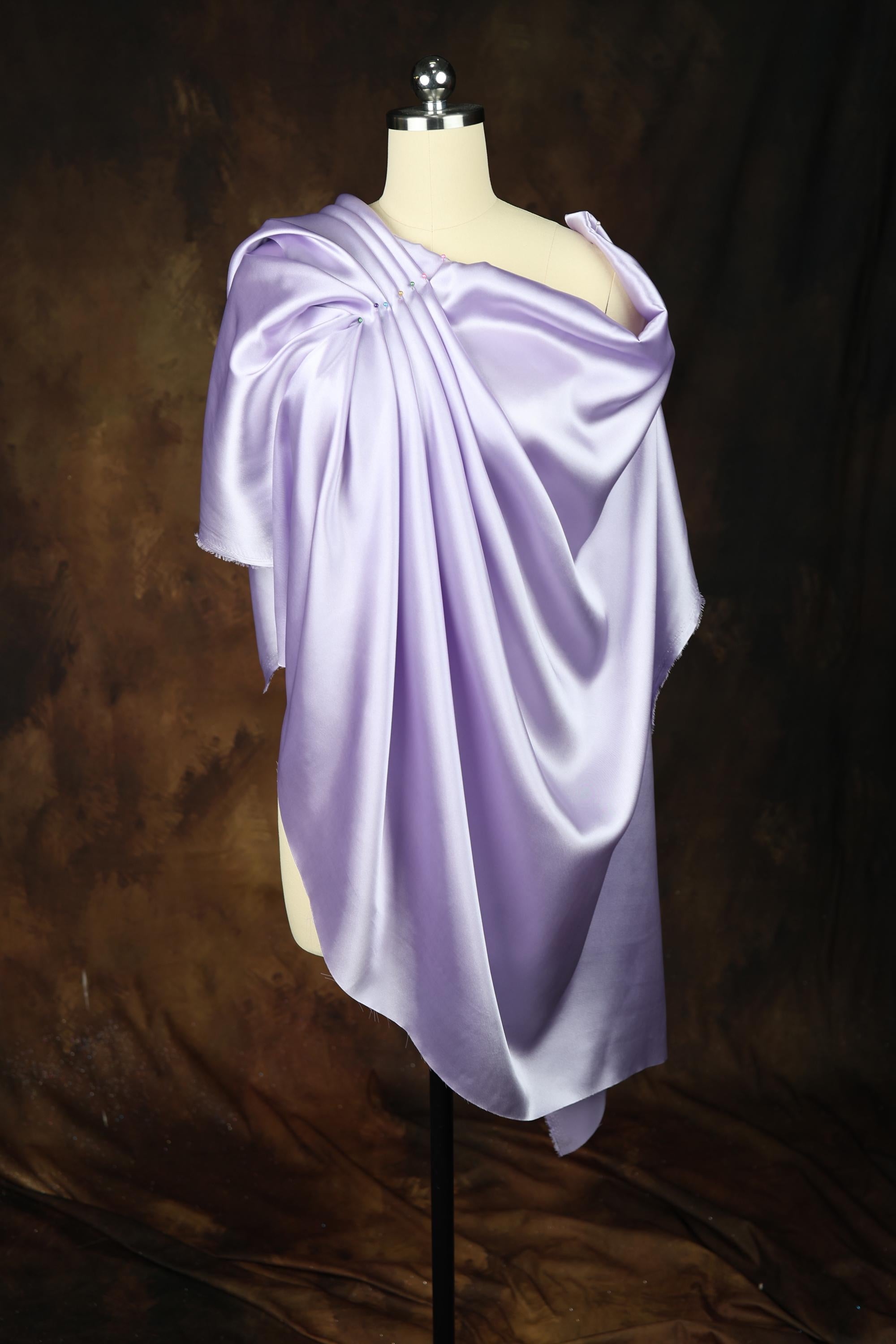 a mannequin wearing a purple draped dress