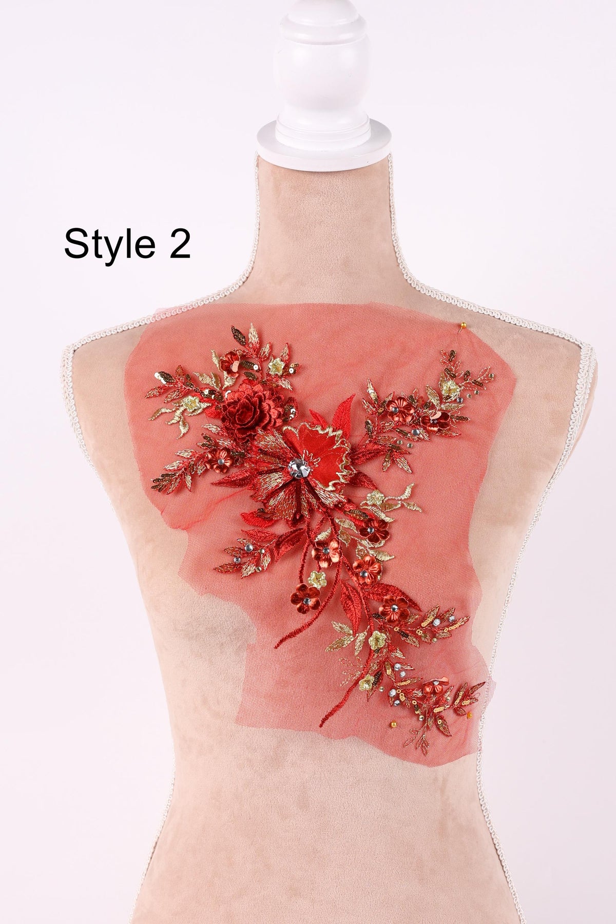 A mannequin with a red floral design on its back, featuring a variety of red flowers and leaves.