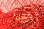 A close-up view of a red sequin fabric, with the intricate patterns and textures of the sequins clearly visible.