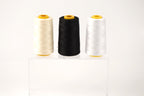 Three spools of thread in different colors - white, black, and beige - are displayed on a clear stand against a white background.
