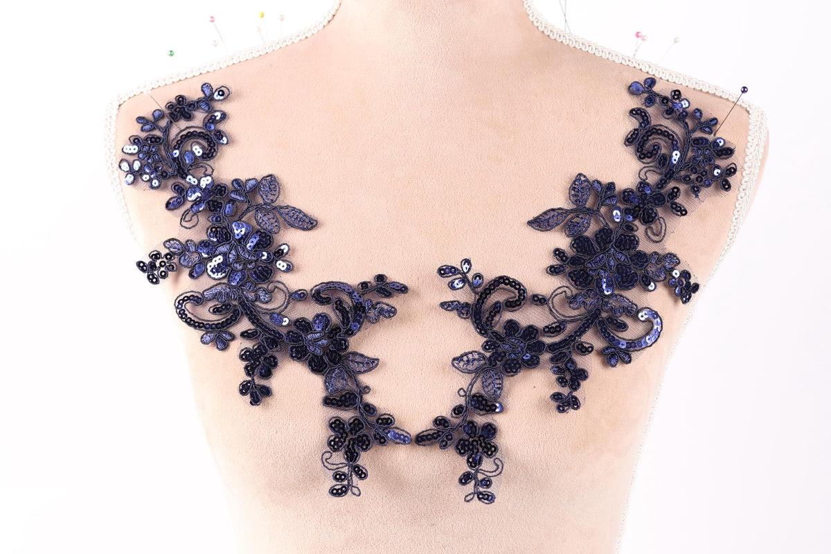 a mannequin with a decorative blue lace or sequin piece on its shoulder.
