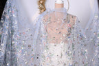 A mannequin wearing a sheer, floral-patterned dress with a sheer, blue-colored fabric draped over it.
