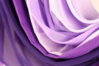 a close-up view of a collection of purple and white fabric, with the colors and textures creating a visually striking and vibrant composition.