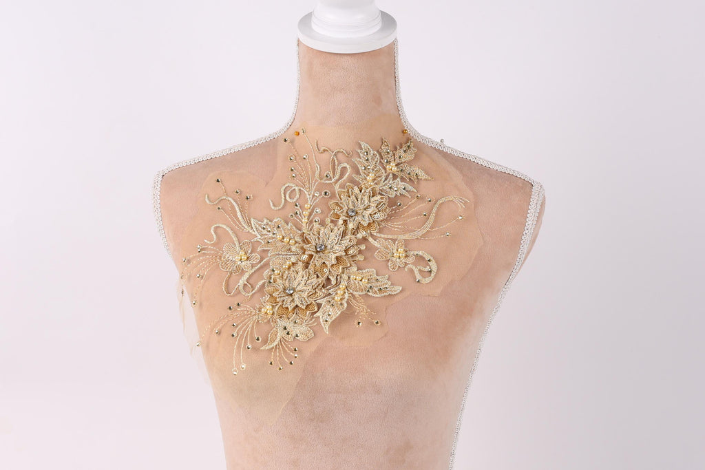 A mannequin with a decorative gold-colored floral embellishment on its bust.