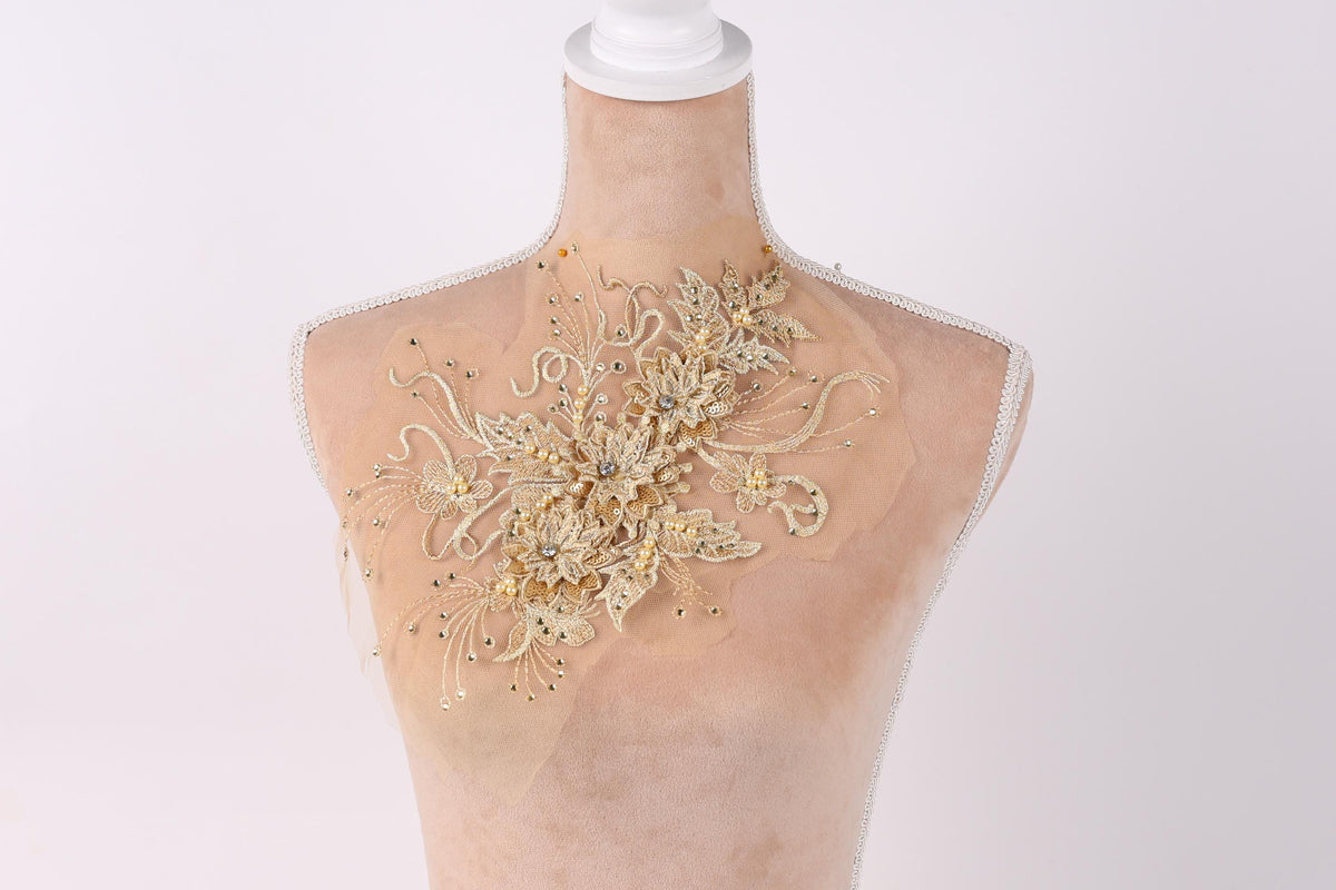A mannequin with a decorative gold-colored floral embellishment on its bust.