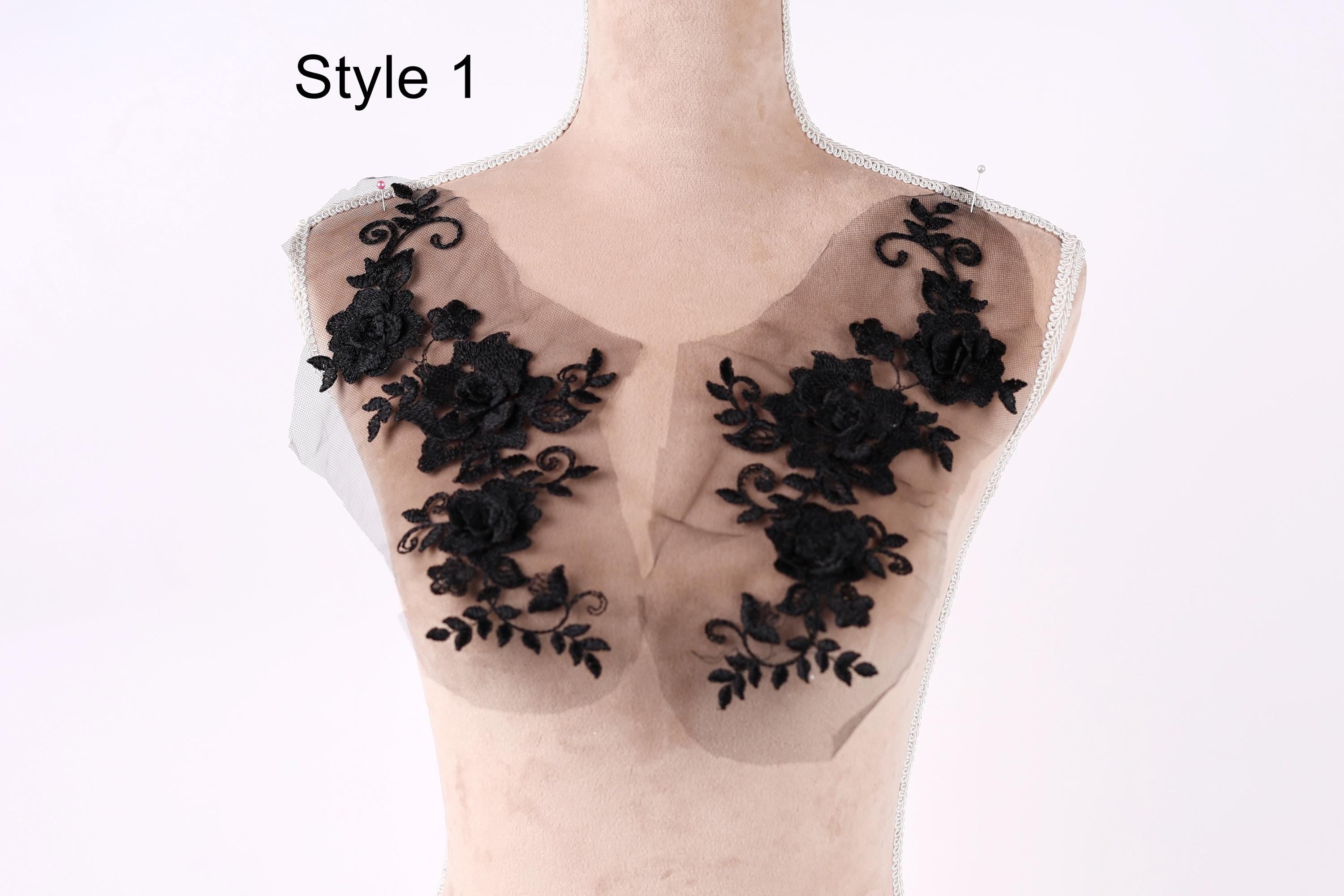 A mannequin with a black lace overlay on its chest area, featuring intricate floral designs.