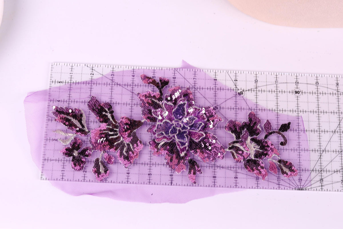 a clear ruler with a purple background, displaying a floral pattern with purple and pink flowers and leaves.