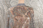 a mannequin wearing a dress with a sheer, sequined bodice. The dress has a floral pattern and appears to be made of a shiny, metallic fabric.