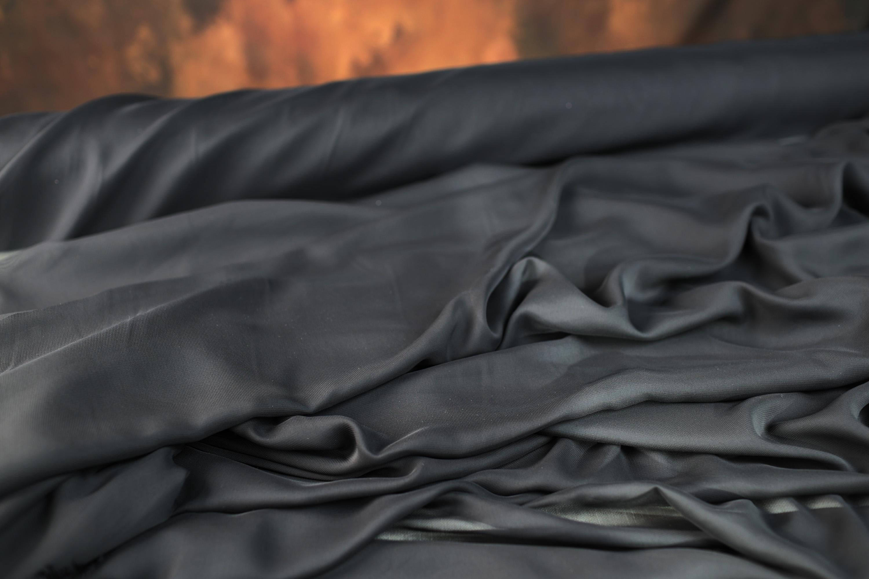 a close up of a black cloth on a bed