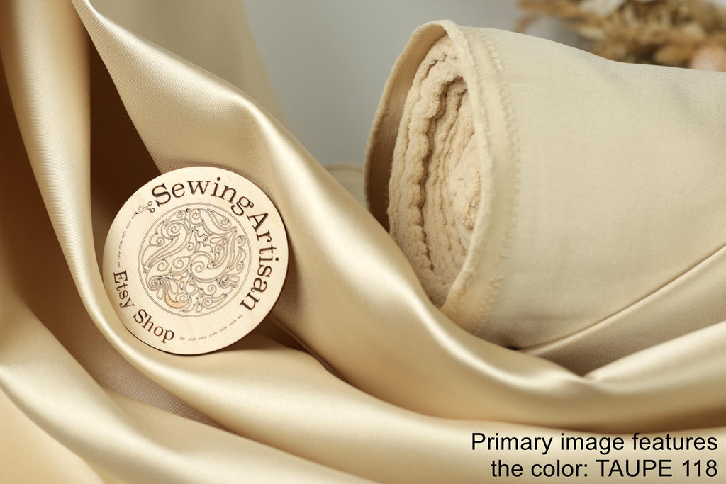 a close-up of a beige fabric with a wooden label that reads "Sewing Artisan Easy Shop" and "Taupe 118".