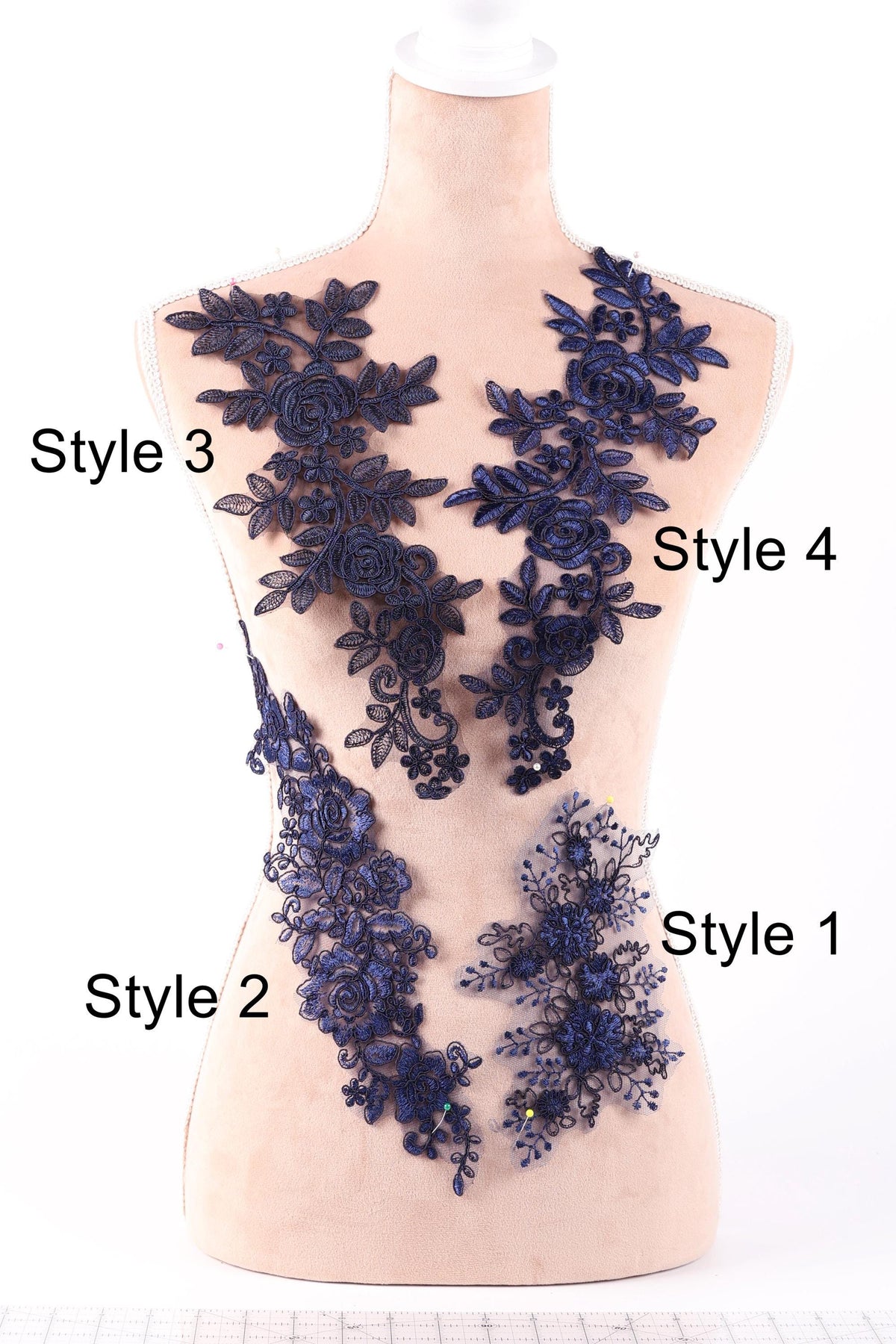 A mannequin with various blue floral and leaf-like designs attached to its torso, each labeled with a different style number.