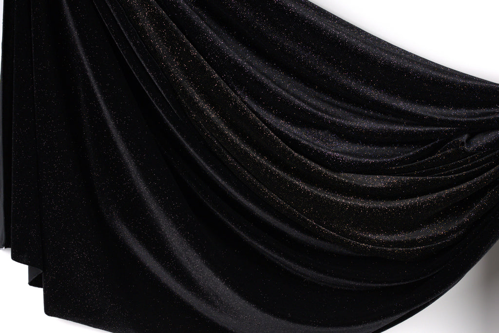 a black fabric with a shiny, glittery texture.