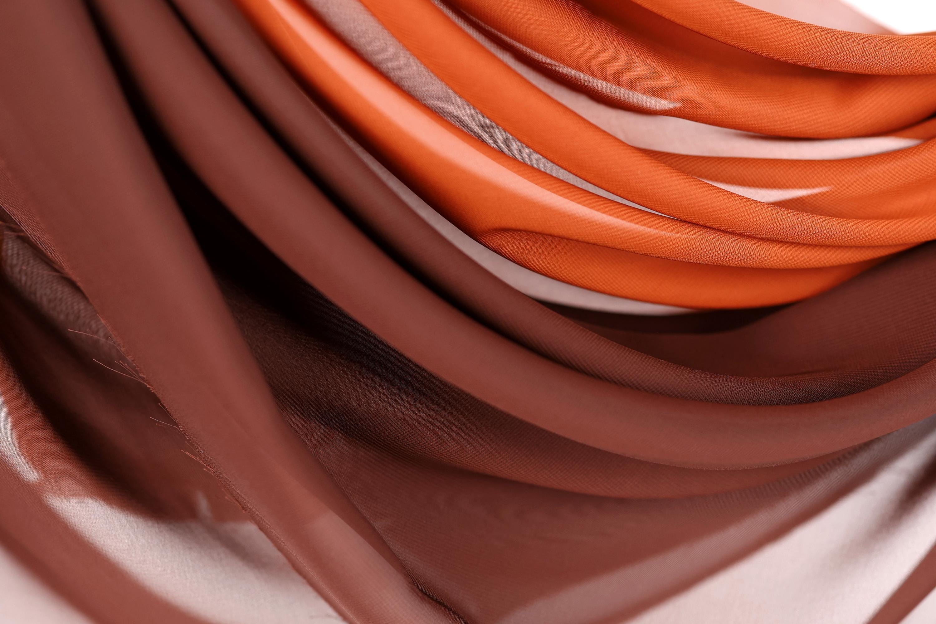a close-up view of a fabric with a mix of brown and orange colors, creating a visually interesting and textured appearance.