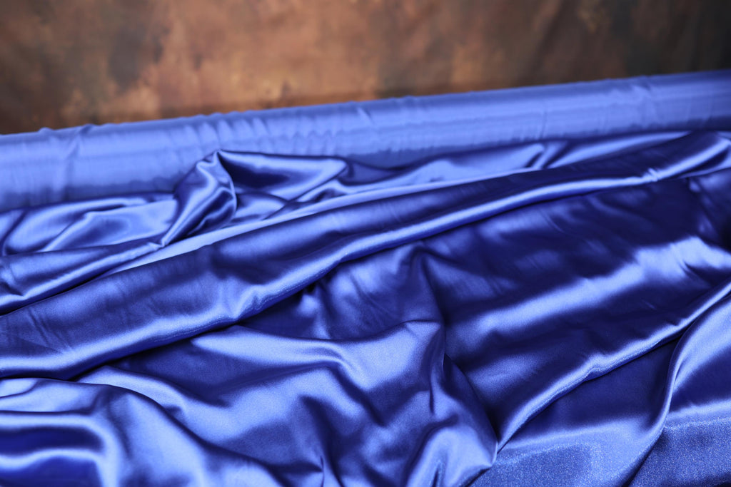 a close up of a blue sheet on a bed