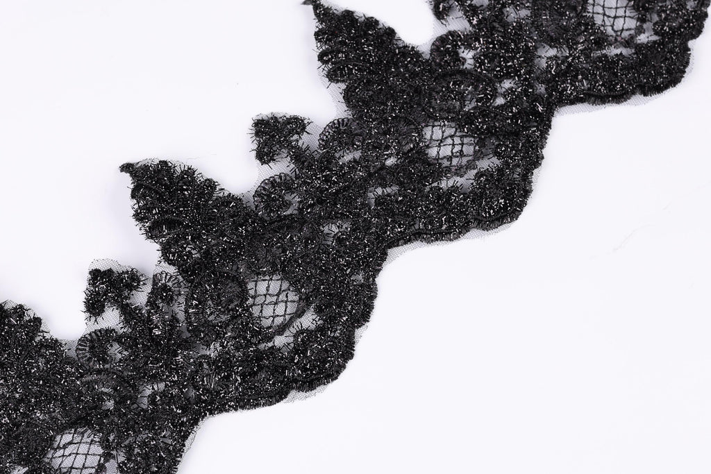 a close-up view of a black lace or fabric with a textured, intricate design.