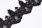 a close-up view of a black lace or fabric with a textured, intricate design.