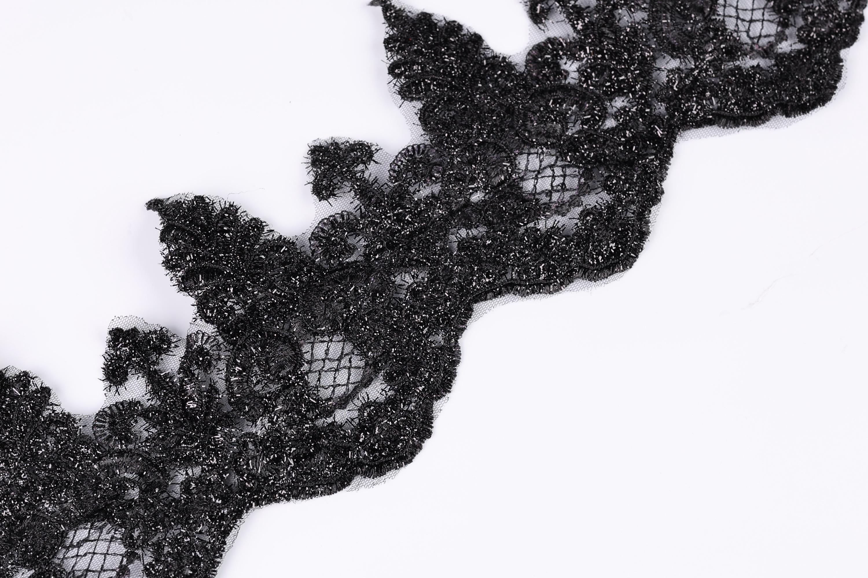 a close-up view of a black lace or fabric with a textured, intricate design.