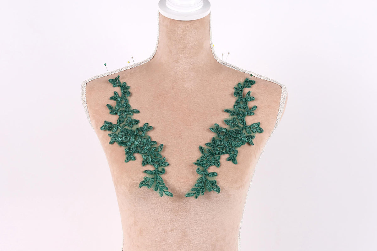 A mannequin with green leaf-shaped embroidery on its bust area.