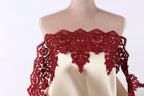 A mannequin wearing a red lace dress with a beige bodice.