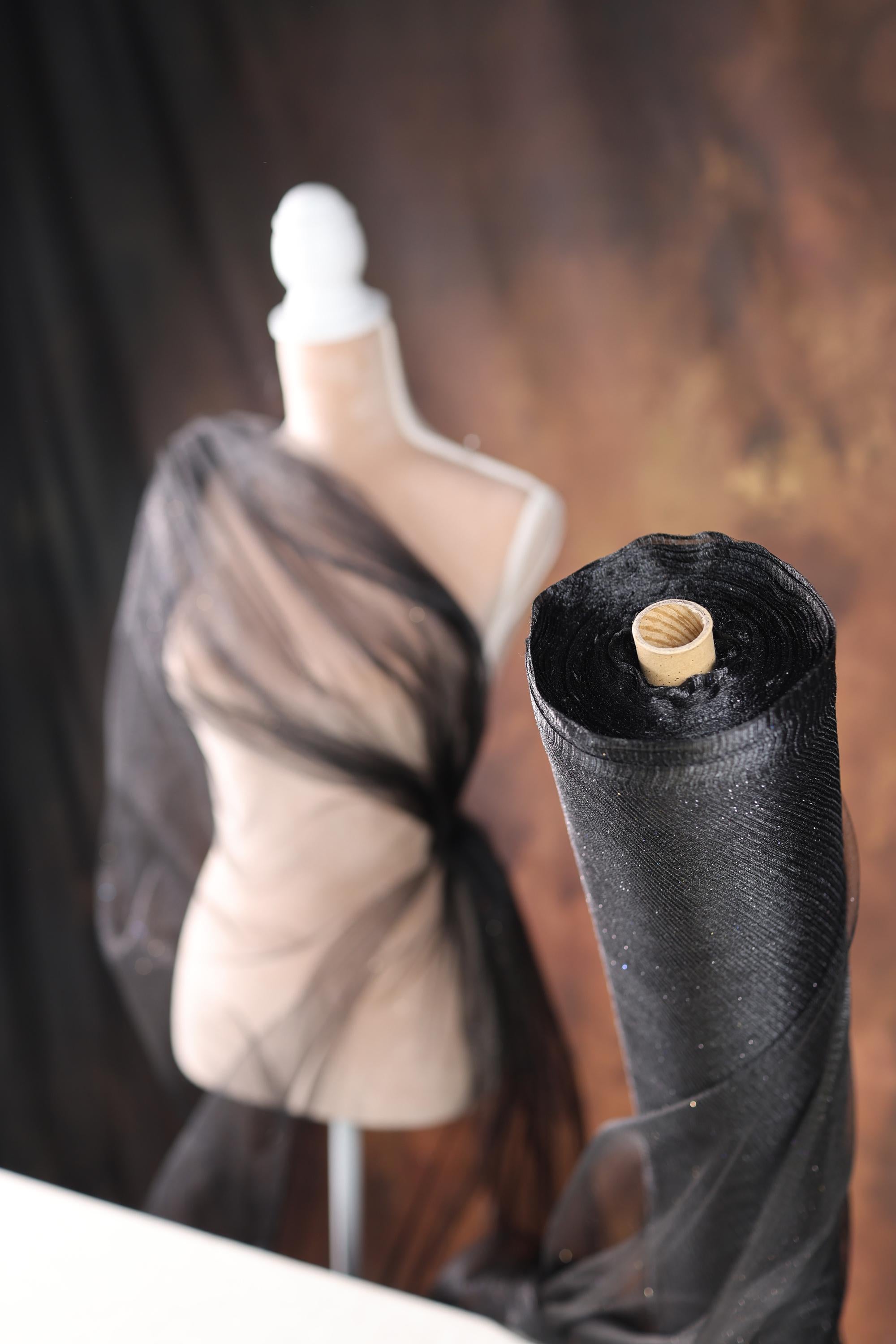 a mannequin is next to a black piece of cloth