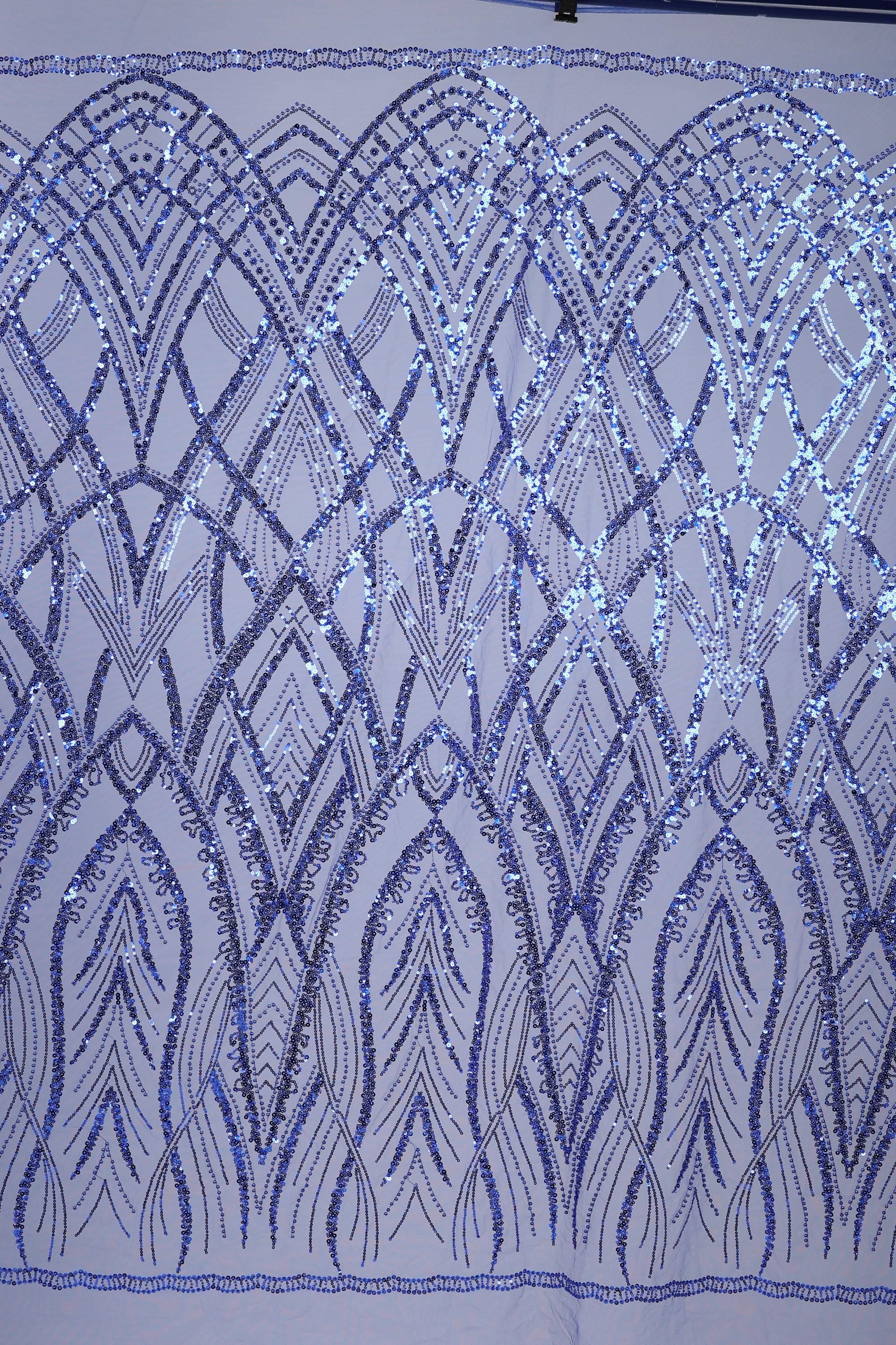 a close-up view of a fabric with a repeating pattern of blue sequin designs. The pattern consists of various shapes and lines, creating a visually striking and intricate design. The fabric appears to be a close-up of a piece of clothing or textile, showcasing the detailed craftsmanship and attention to detail in the design.