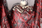 a red and black sequined dress with a sheer black overlay, displayed on a mannequin.