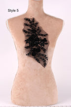 A mannequin with a decorative black lace piece on its back.