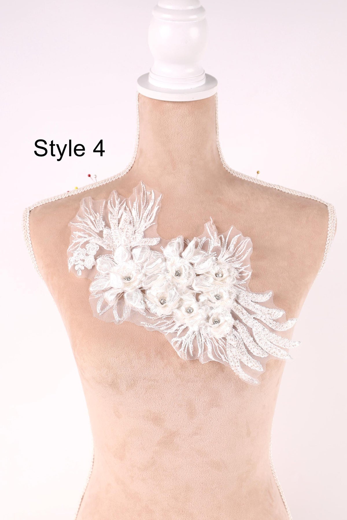 A mannequin with a decorative white lace flower on its bust, displayed against a plain background.
