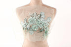 A mannequin wearing a dress with a floral embroidered design on the back.