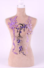 A mannequin with a beige body and purple floral embroidery on its torso.
