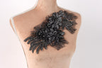 A mannequin torso with a decorative black floral embellishment on the left side.