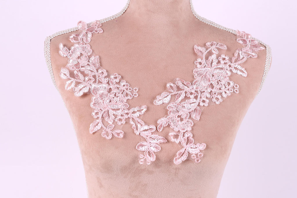 A mannequin with a pink floral lace design on its bust area.