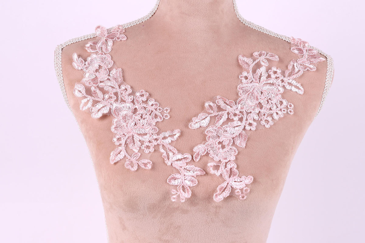 A mannequin with a pink floral lace design on its bust area.