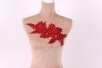 A mannequin with a red floral embellishment on its chest against a white background.