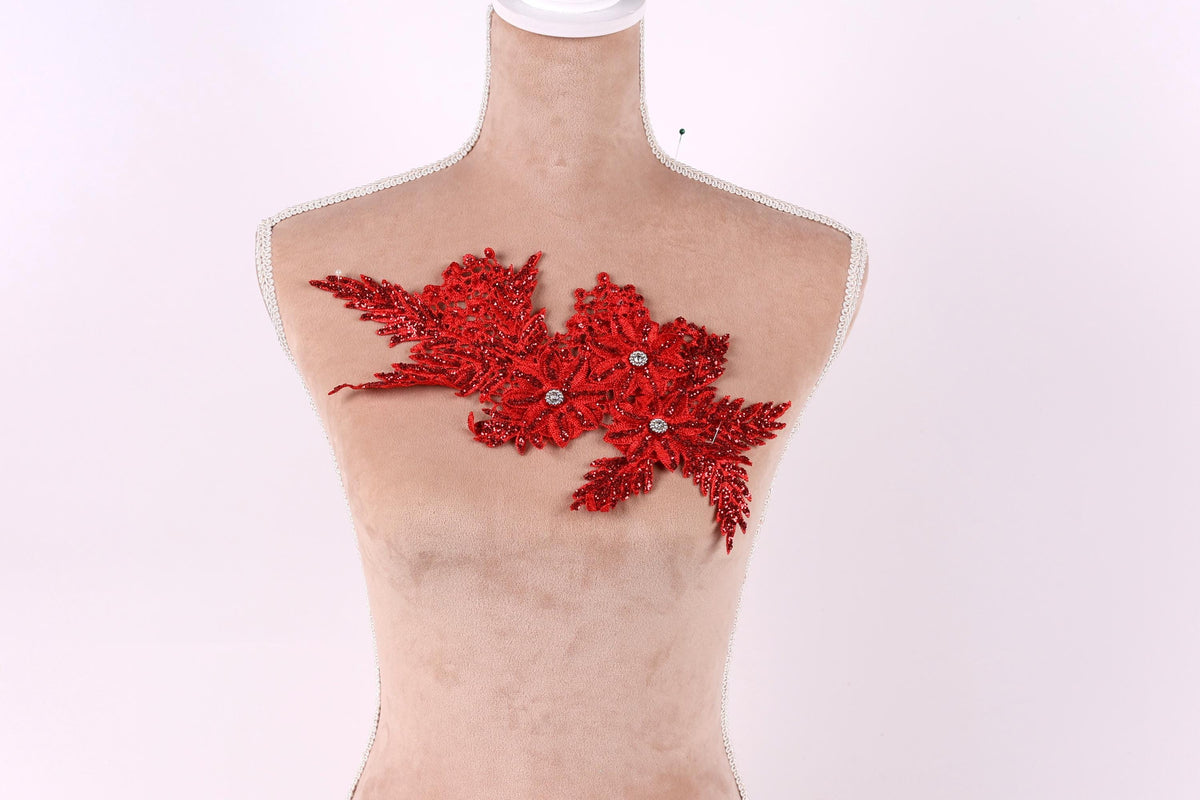 A mannequin with a red floral embellishment on its chest against a white background.