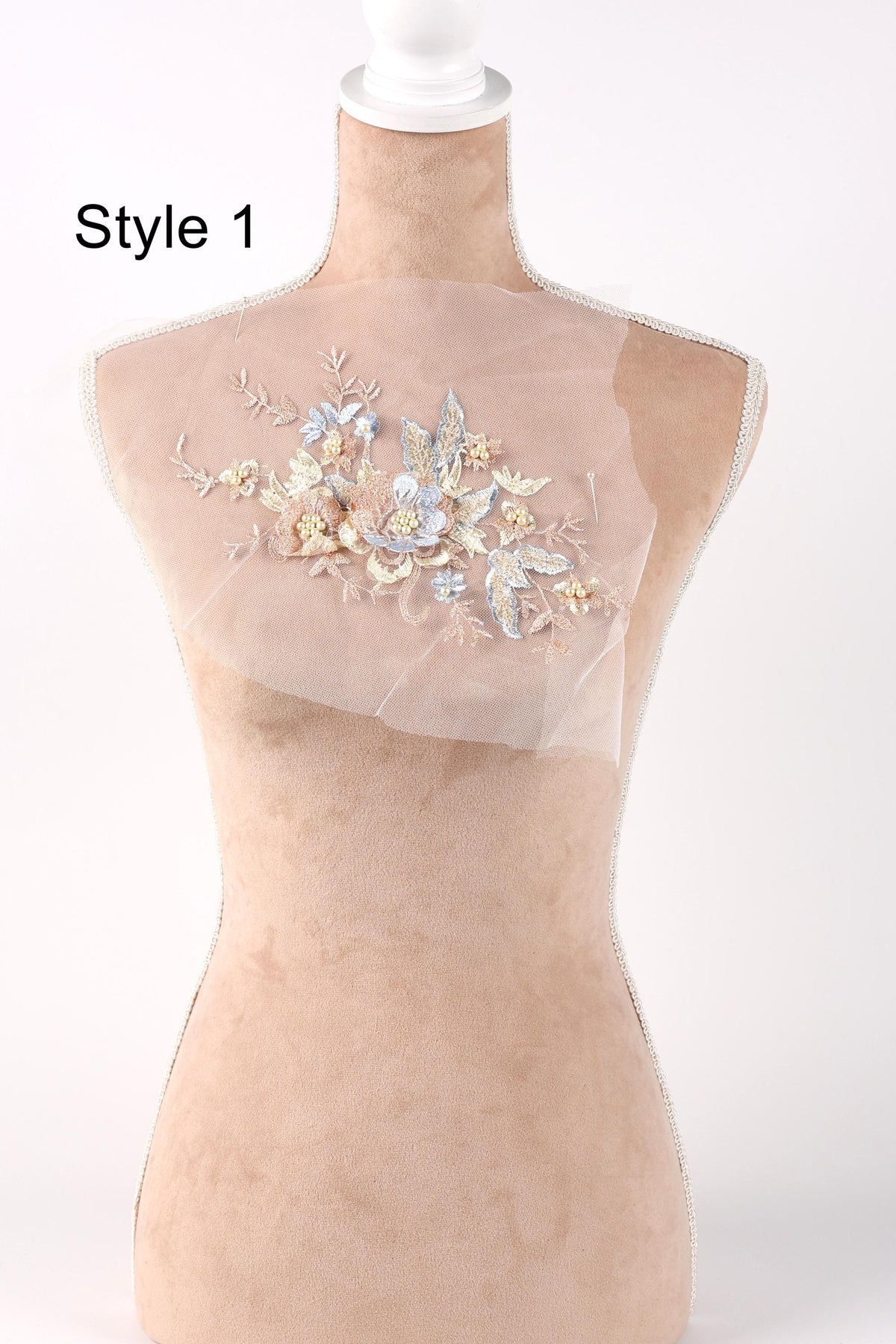 A mannequin with a floral embroidered patch on its bust, displayed against a plain background.