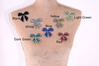 A mannequin torso with seven different colored and patterned rhinestone or crystal-like embellishments attached to it, each labeled with a color and pattern.