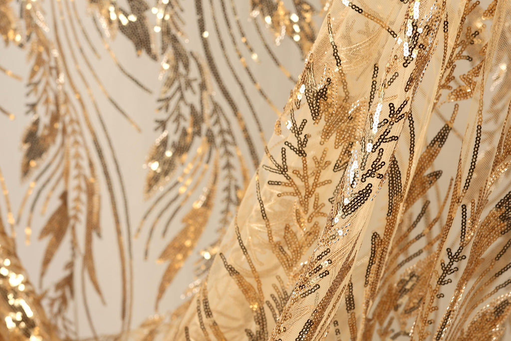 a close-up view of a fabric with a gold and black sequin pattern, creating a visually striking and intricate design.