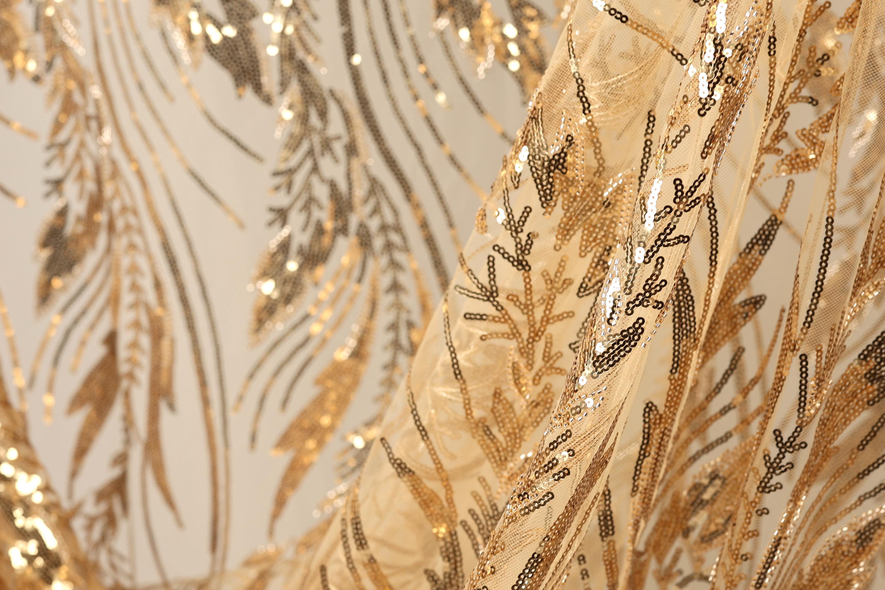 a close-up view of a fabric with a gold and black sequin pattern, creating a visually striking and intricate design.