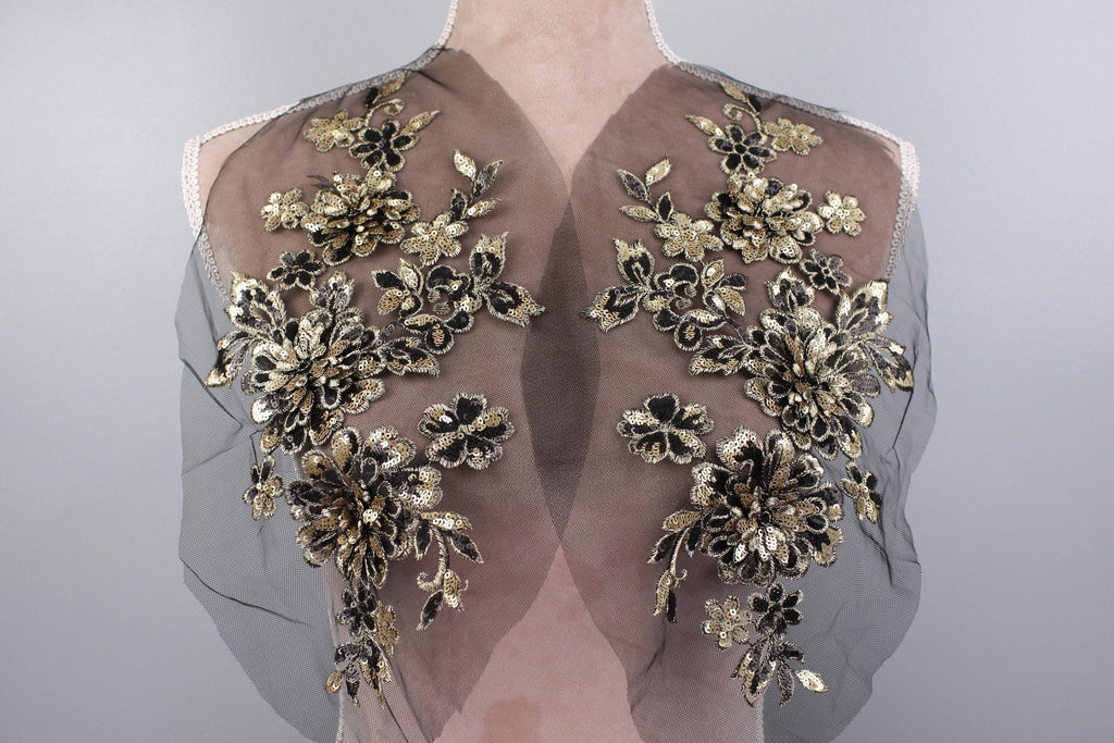 the back of a dress with gold flowers on it
