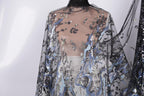 a close-up view of a sheer, black and blue sequined fabric draped over a mannequin.
